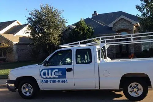 A Caprock Window Cleaning truck with a ladder rack and the phone number 806-790-9944 on the door, on a suburban Lubbock street