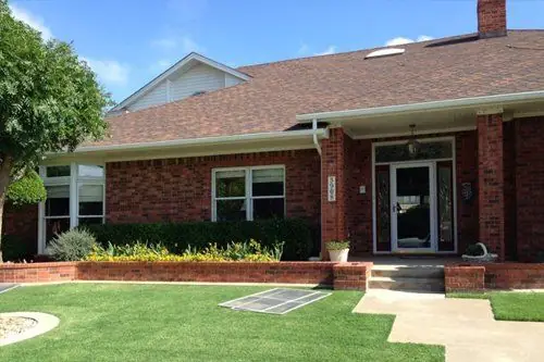 A red brick ranch home in Lubbock with a glazed front door